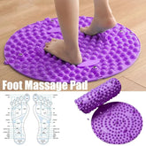 Purple foot massage pad with feet on a wooden floor, showing detailed diagram of foot pressure points.